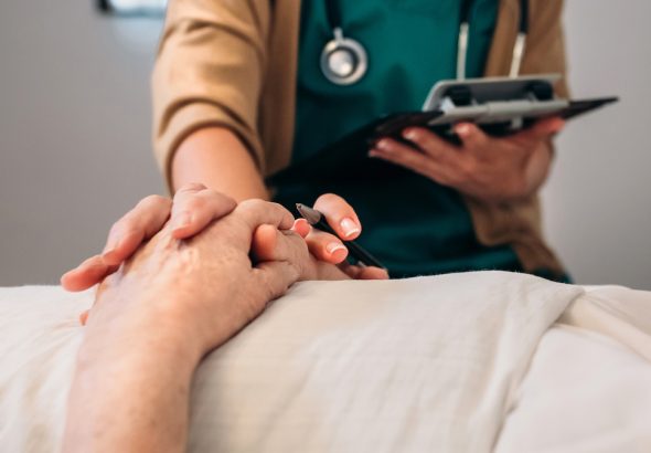 Médico joven consolando a paciente mayor