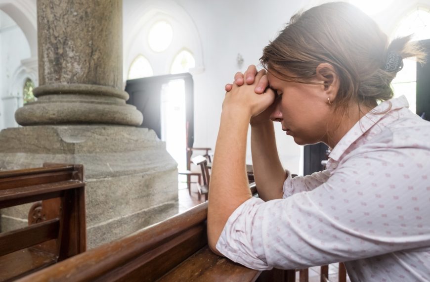 Mujer rezando en iglesia pidiendo ayuda a Dios.