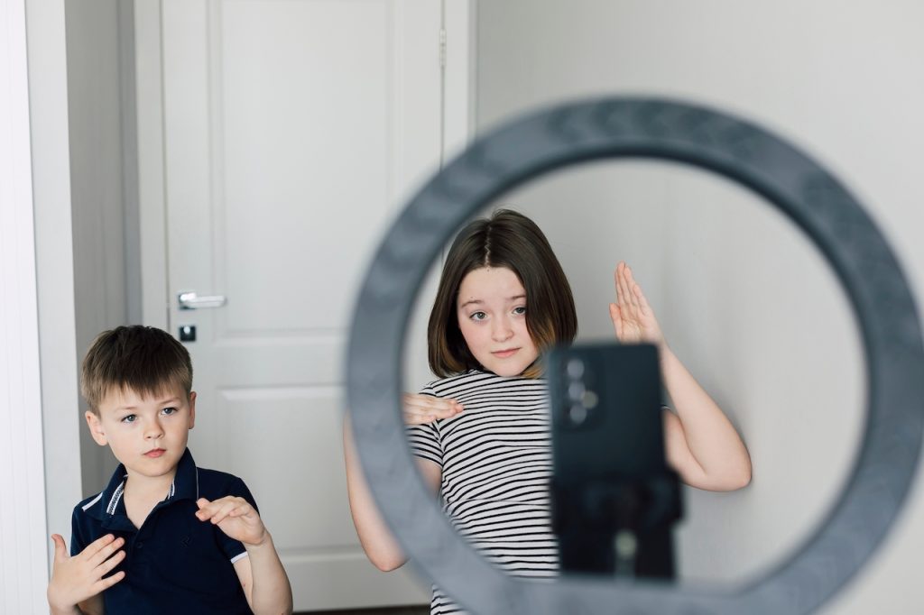 Niños frente a pantalla haciendo video para Tik Tok