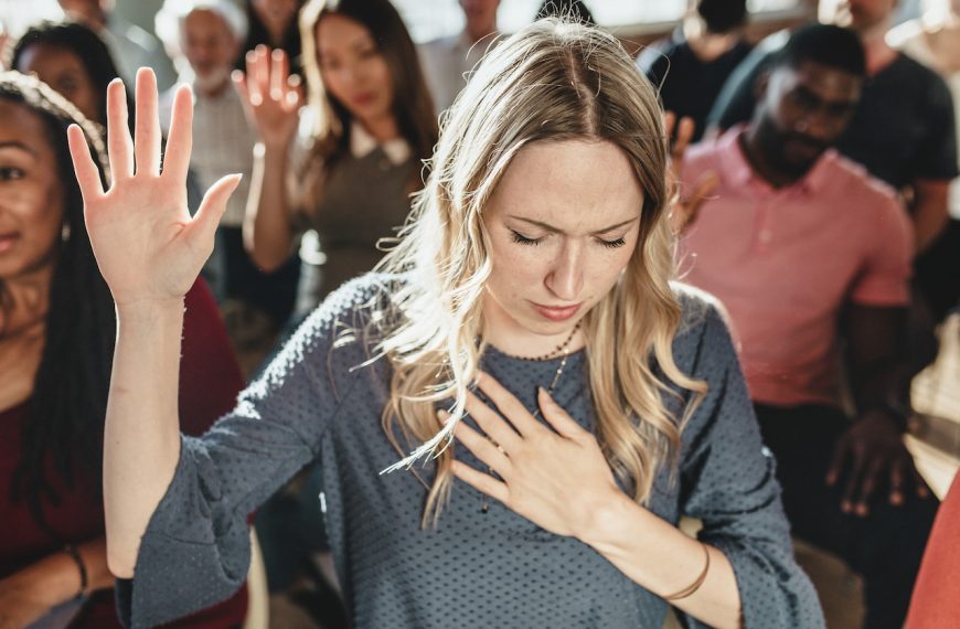 Mujer levantando la mano en señal de oración. (Imagen ilustrativa)