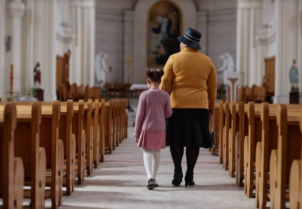 Vista trasera de la abuela visitando a la iglesia junto con su nieta